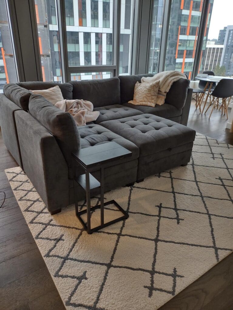 A clean living room in a high rise apartment with a view out to the city to help illustrate Spring Cleaning and to help illustrate Spring Cleaning Checklist and pre-vacation cleaning checklist