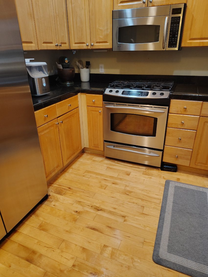 A clean kitchen with stainless steel appliance to help illustrate Summer House Cleaning Checklist