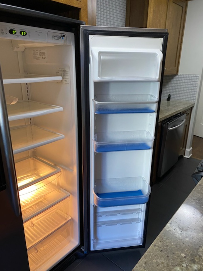 Refrigerator with the door open, showing cleaned shelves and door bins inside and out