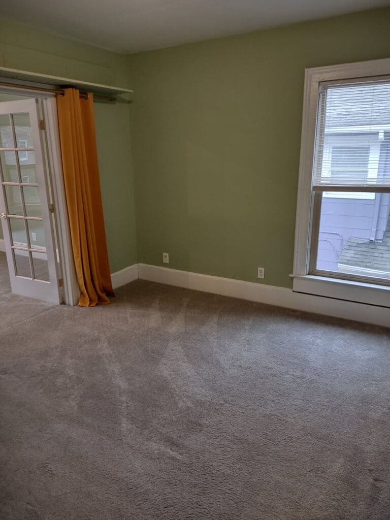 An empty bedroom with clean carpeting to show bedroom cleaning services