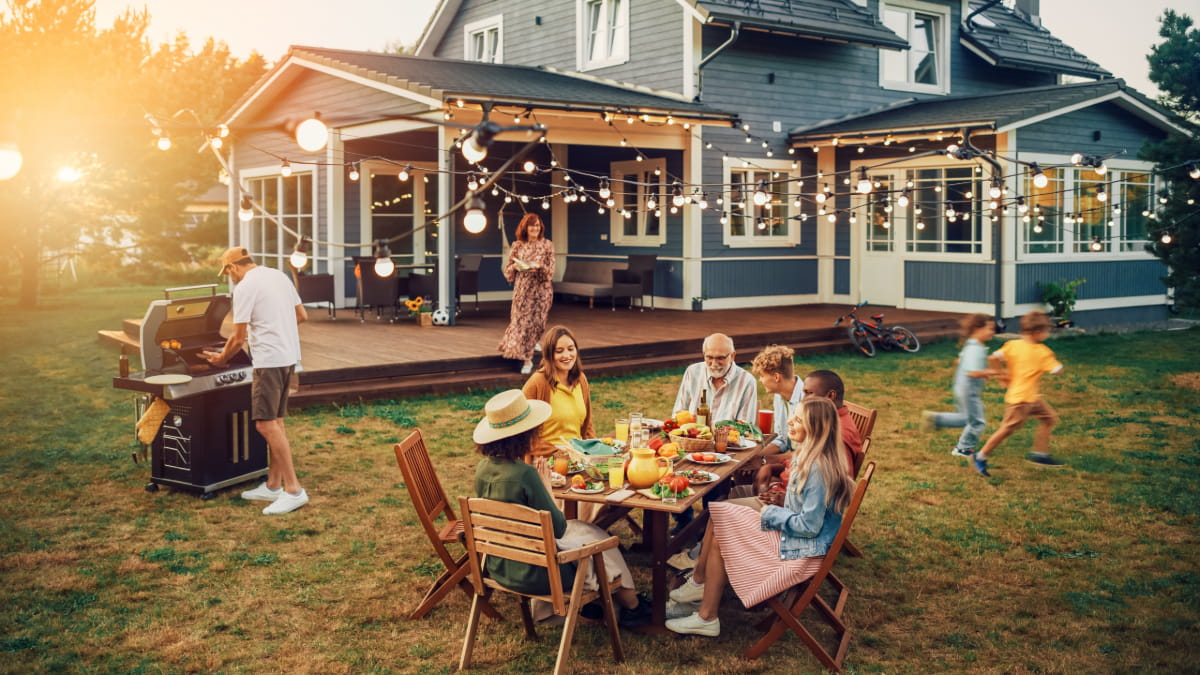 Family and friends celebrating outside at home after completing their summer house cleaning checklist.